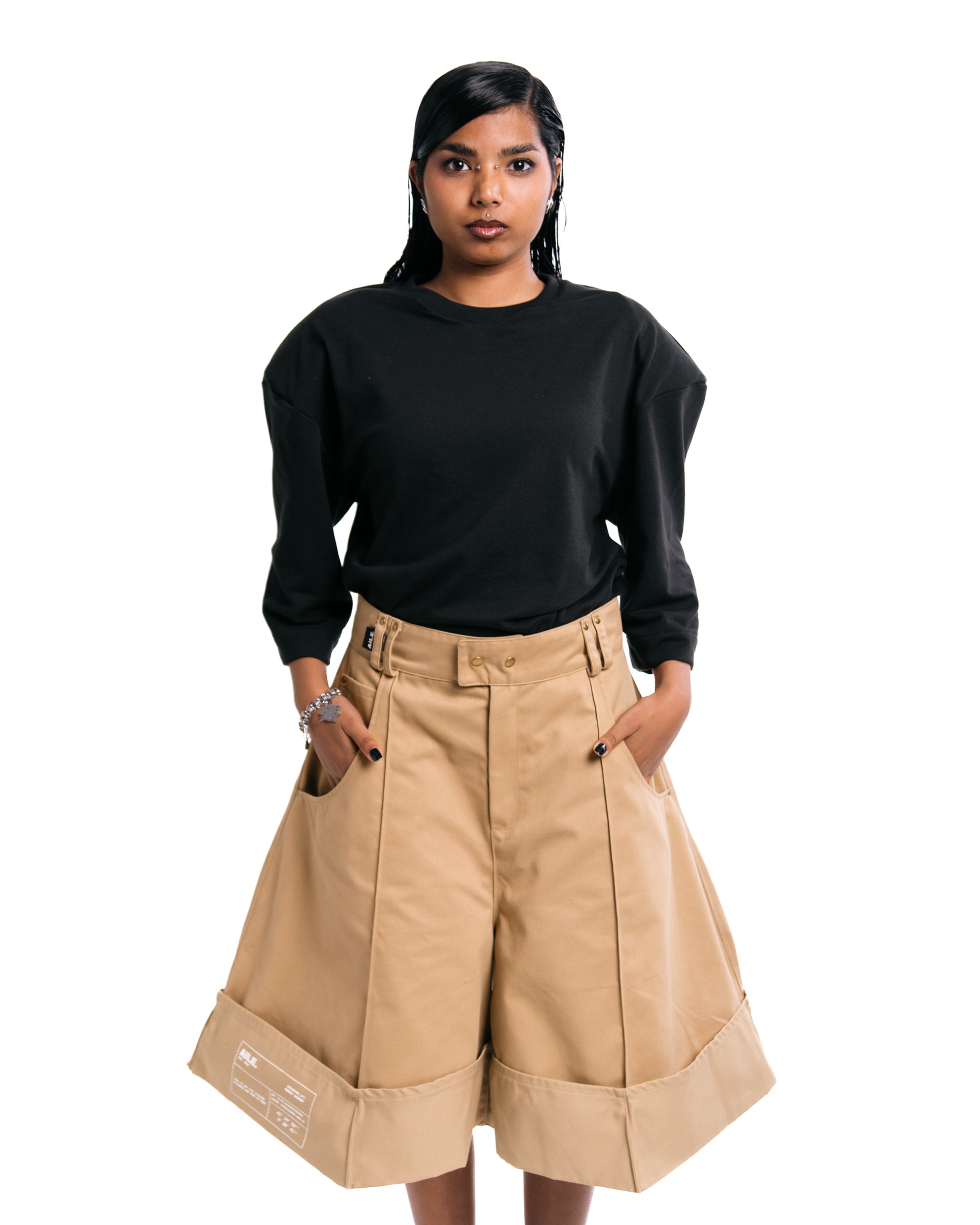 Bermudas en tejido sarga, corte triangular oversize en color beige con detalle estampado blanco en la pernera.AILE