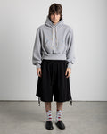 Capri tracksuit pants with double waistband and adjustable straps in the legs. Balloon or oversize shape.